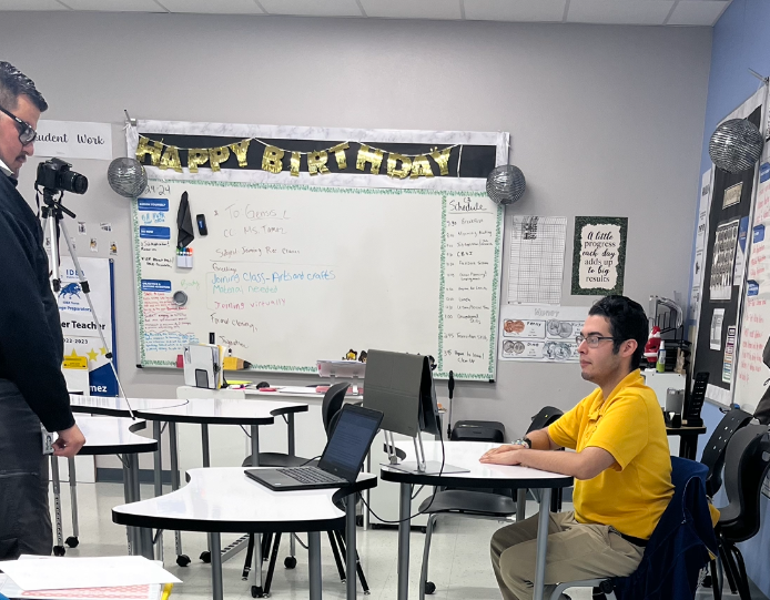 Teacher is standing and student is seated while practicing interview skills