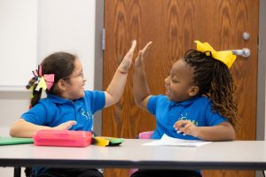 Two students giving each other a high five